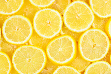A slices of fresh juicy yellow lemons.  Texture background, pattern.