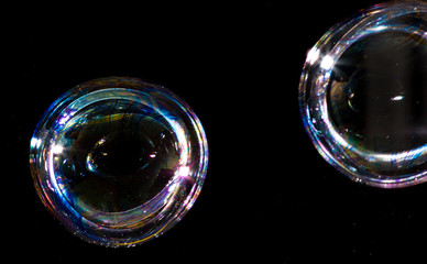 Multicolored soap bubbles close up on a black background