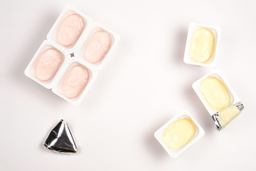 Plastic cup with tasty yogurt isolated on white. Top view. Space for text or design.