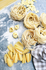 Mixed types and shapes of italian pasta on grey stone, background