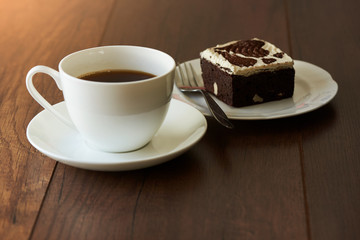 A cup of hot coffee and a piece of chocolate cake