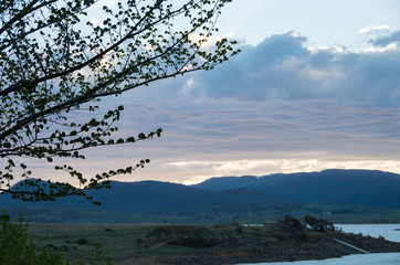 Obraz na płótnie Canvas Soft Fluffy clouds near sunset over mountains