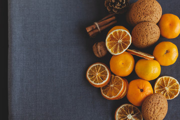 Tangerines, spices, pine cones and orange slices table. Traditional Christmas winter background, wallpaper or greeting card. Horizontal, toned image. Top view, flat lay, background, copy spaces. 