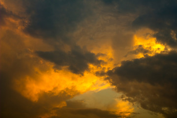 bright orange gray storm clouds in a dark sunset sky. rain clouds in the sky.
