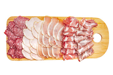 Assorted meat delicacies on a wooden cutting board, isolated