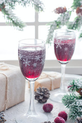 Festive berry liqueur in glass Christmas glasses on the table in the Christmas decorations, selective focus
