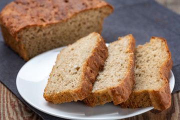 whole grain or whole wheat bread, slices of homemade bread on white plate