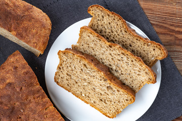 whole grain or whole wheat bread, slices of homemade bread on white plate. Top view