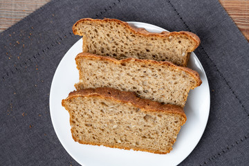 whole grain or whole wheat bread, slices of homemade bread on white plate. Top view