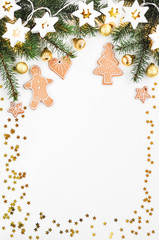 Holiday shiny background. Traditional gingerbread cookies like a funny little man, stars, hearts, tree and gold boll with lights garland stars and fir branche. Christmas ornaments