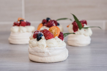 Pavlova meringue cake with cream and small fruits