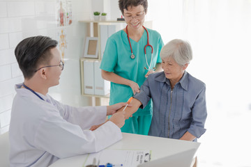 Obraz premium doctor and nurses treatment for elderly patient with osteoporosis