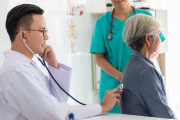 doctor checking heart patient elderly