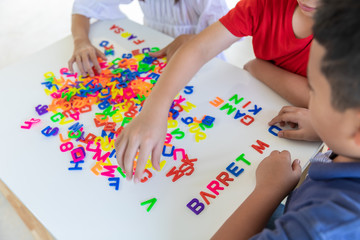 children playing jigsaw letters on the table