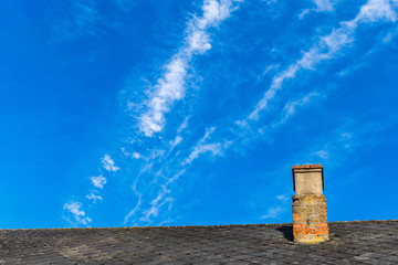 country house roof top with chimney on blue sky