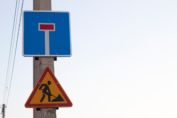 Bright yellow triangular warning sign; Attention, work ahead, and Dead-end street on square blue...