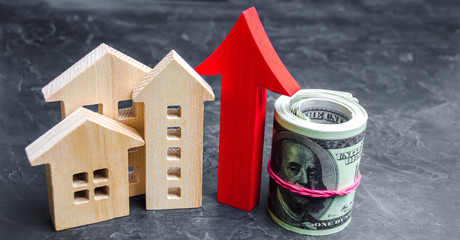 Wooden houses with a red arrow up. concept of high demand for real estate. increase energy...