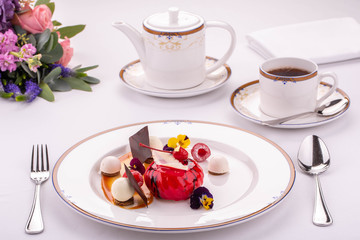 Giving of a dessert at restaurant with a teapot of black tea and vanilla balls of ice cream