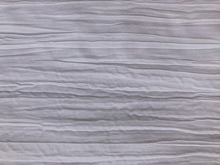 Fototapeta na wymiar White fabric with a crumpled effect and horizontal creases