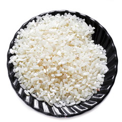 Black saucer with a handful of raw dry white rice on a white background. Isolated