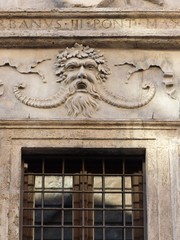 Soprafinestra con la faccia di Bacco al palazzo dei Pupazzi a Roma in Italia.
