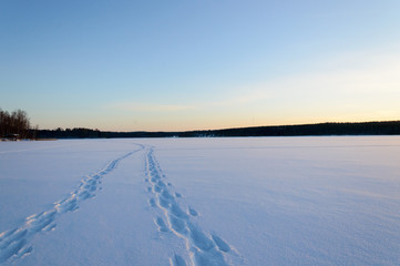Fototapeta na wymiar Foot steps on skandinavien winter frozen lake