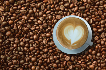 Top view of  a coffe cup on coffee beans background