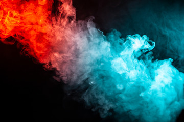 A column of colored smoke of green and red color from a wap of an abstract form tending upwards on a black isolated background.