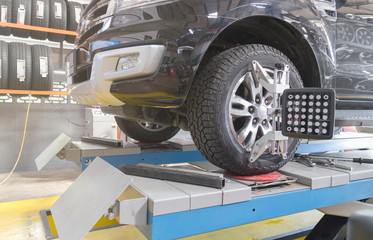 A Car on the Car Steering Wheel Balancer and Calibrate with laser reflector attach on each tire to center driving adjust in the garage