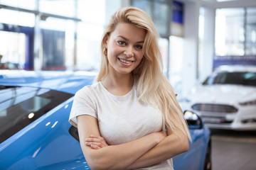 Happy beautiful young woman smiling to the camera confidently, standing in front of her new...