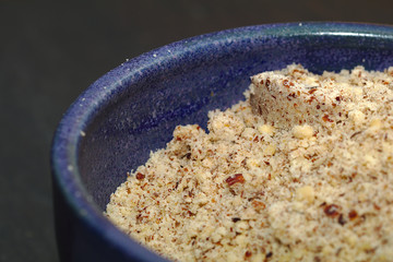 Makro Foto einer blauen Porzellanschale mit gemahlenen Nüssen