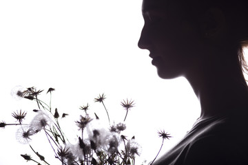 silhouette portrait of a girl with a bouquet of dry flowers, face profile of a dreamy young woman on a white isolated background