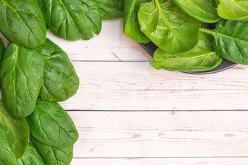 Fresh spinach leaves on rustic wooden table. Top view. With Copy Space