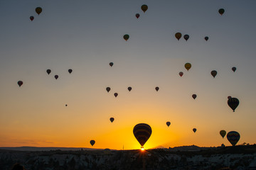 Beautiful sunset over Cappadocia, Goreme. Balloons flying against sky, aerial view. Most popular place in Turkey