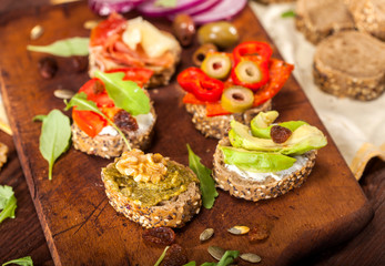 Collection of sandwiches on a cutting board and wooden table