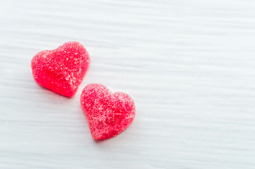 Fototapeta premium Two small red hearts on a white background. Greeting card. Valentine's Day