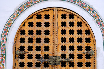 Closed carved wooden gate in rustic style. Close up.