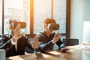 Two business business persons with virtual reality headsets in the office.