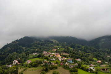 Fototapeta na wymiar View of high plateau village, mountains, valleys and forest in fog creating beautiful nature scene. The image is captured in Trabzon/Rize area of Black Sea region located at northeast of Turkey.