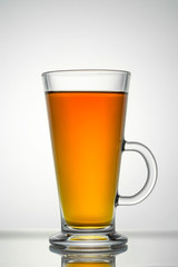 Tea in a transparent cup on a white background, close-up