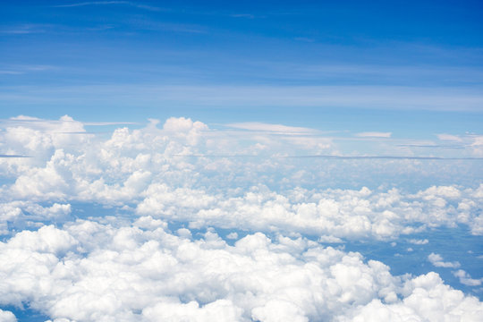 Top view on plane of Blue sky and white puffy clouds. © Chanintorn.v