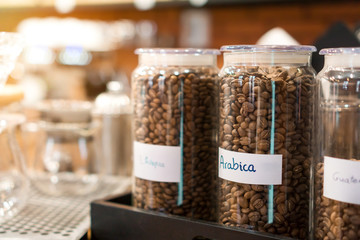 coffee beans with name arabica label in bottle at coffee shop, Selective focus.