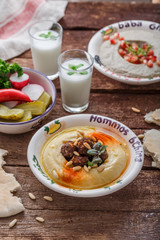 Hummus with meat and paprika on rustic table