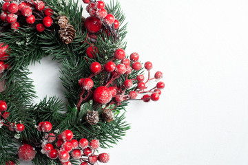 Christmas decorative wreath of holly, ivy, mistletoe, cedar and leyland leaf sprigs with red berries over white background.