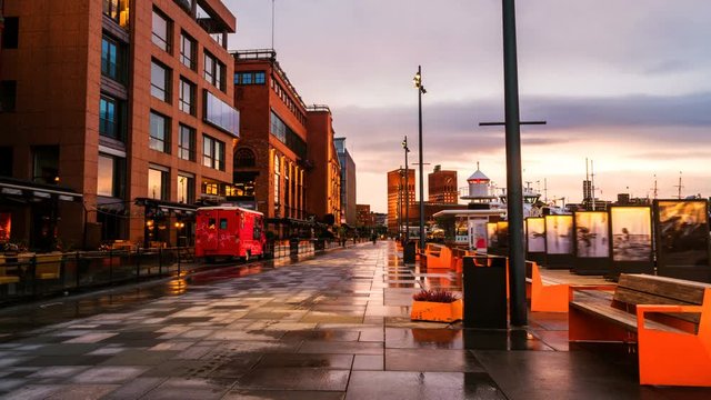 Oslo, Norway. Downtown Oslo, Norway, on a cloudy morning, with moored boats and minimalistic scandinavian-style buildings on the background. Time-lapse of empty promenacde area at sunrise