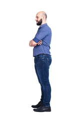 Fototapeta premium A young bearded guy stands sideways and looks away. Isolated on white.