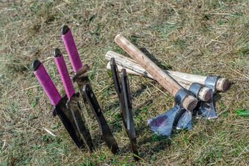 Throwing knifes stabbed in the grass. Stainless steel knifes on a green garden background.