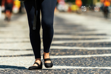 Close-up of legs of middle-aged woman walking on a Copacabana sidewalk in Rio de Janeiro, Brazil