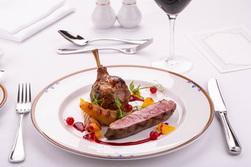 A leg of a turkey with the vegetables fried on a grill with a cranberry in cranberry sauce