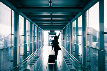 Back side of an asian woman walking to the aircraft at the airport.